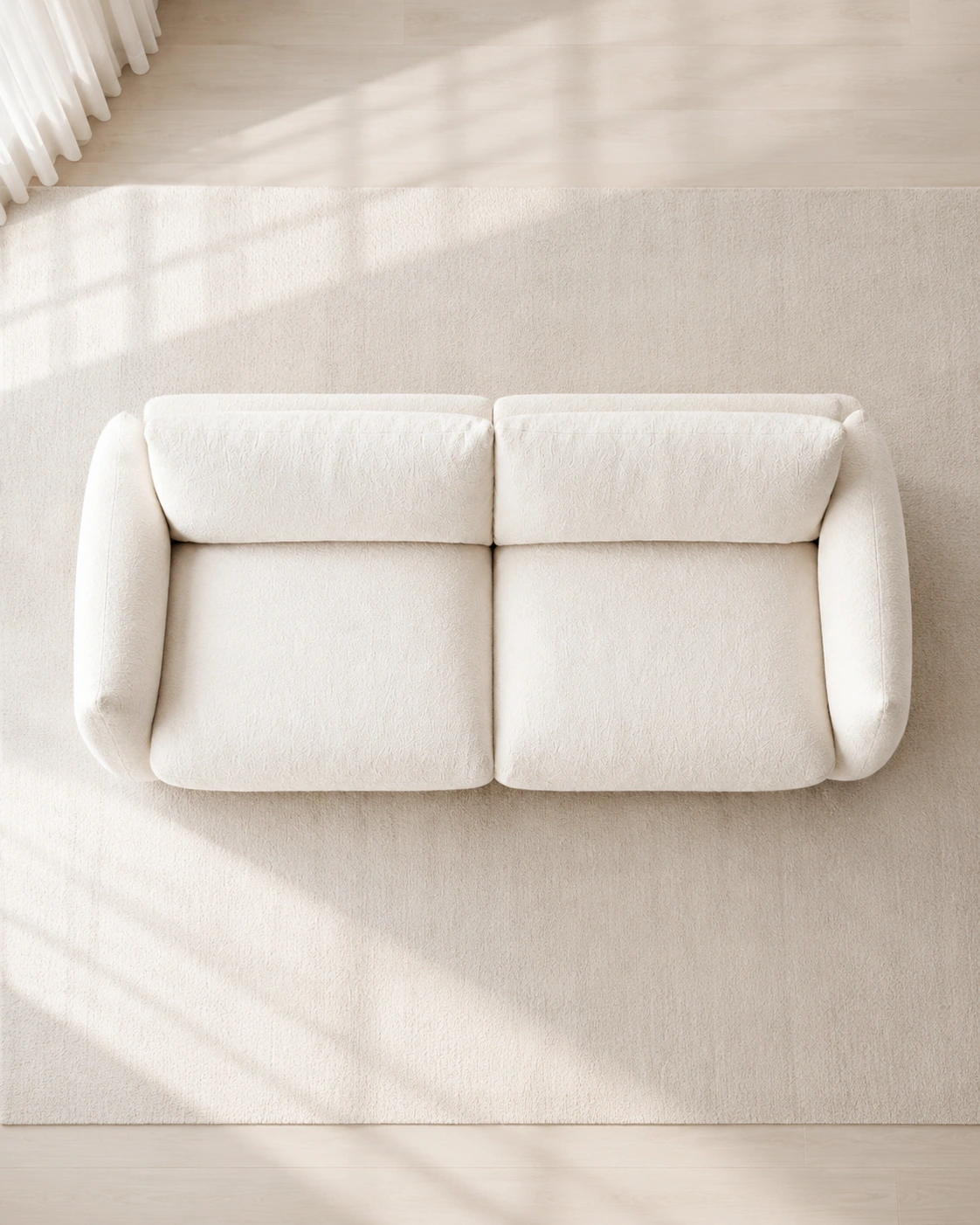 Top view of an ivory boucle sofa in a bright neutral interior