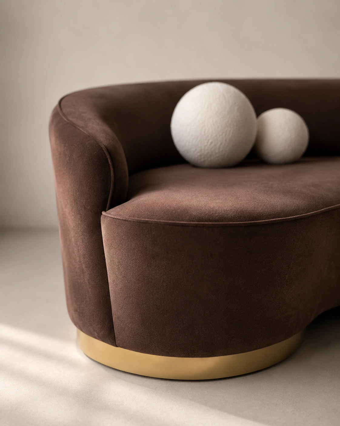 Close view of the sculptural cocoa sofa with ivory sphere cushions