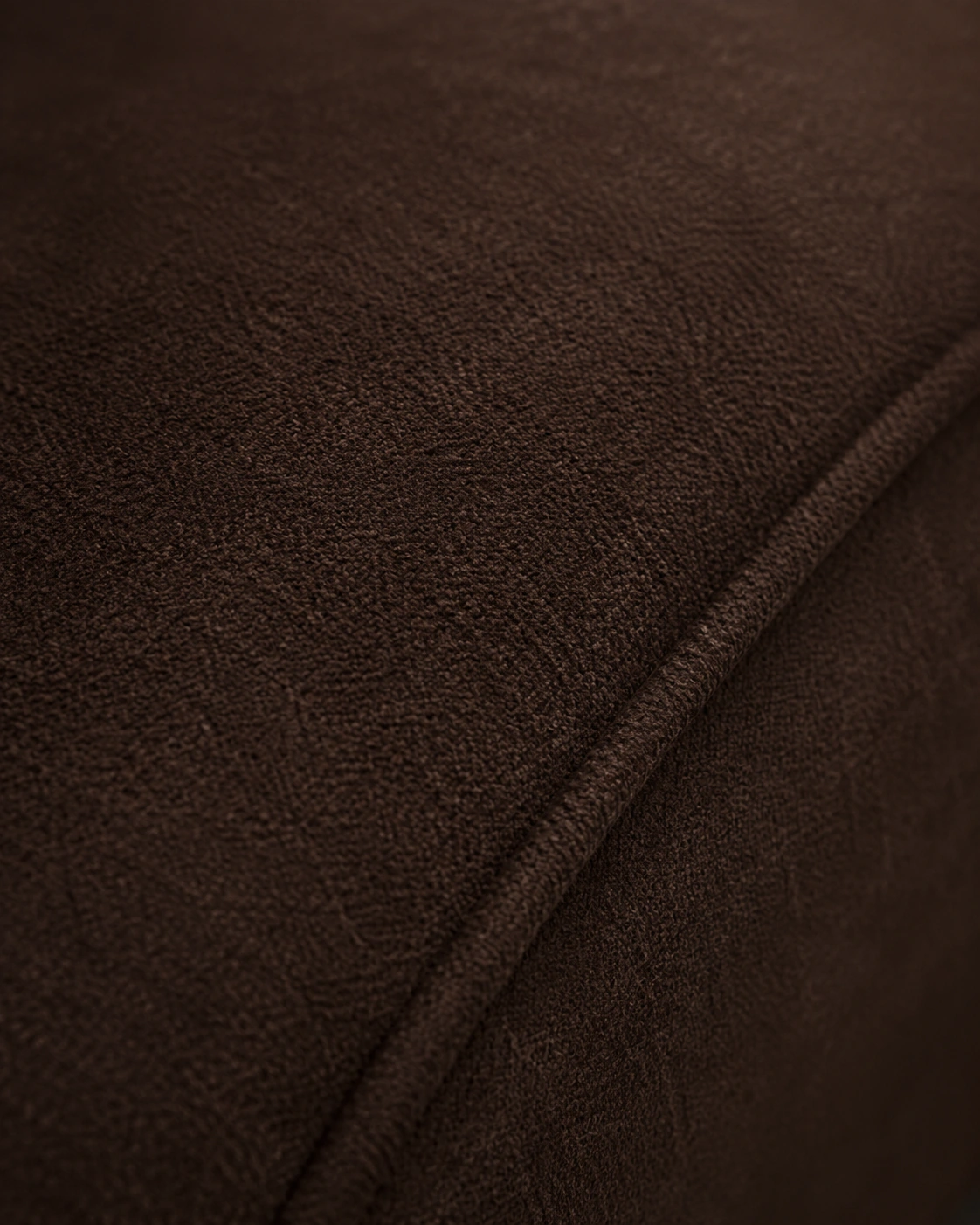 Macro detail of the sofa's deep cocoa upholstery