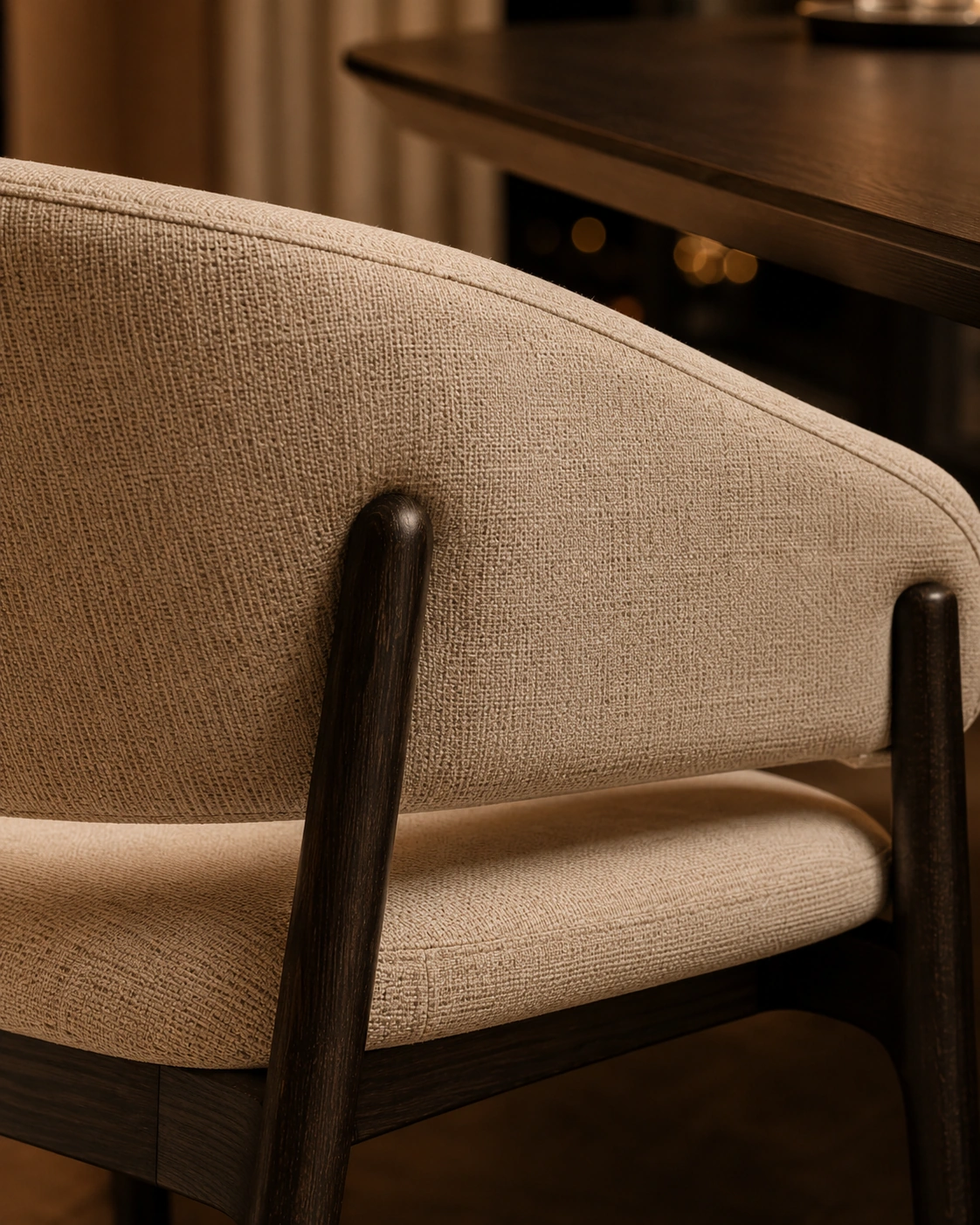 Detailed view of an ivory boucle chair with a walnut frame