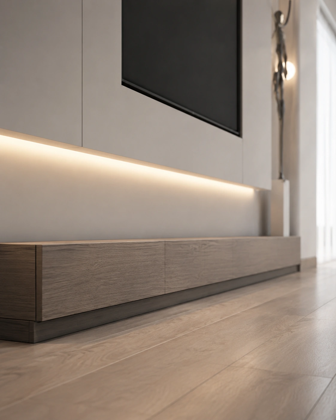 Angled view of a minimal white TV wall with walnut drawers